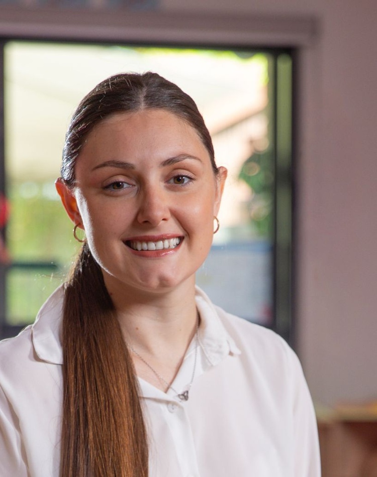 Woman smiling at camera with white collared shirt