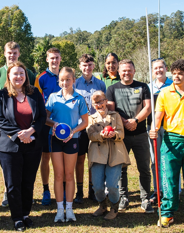 A group of people on a sports oval looking at the camera
