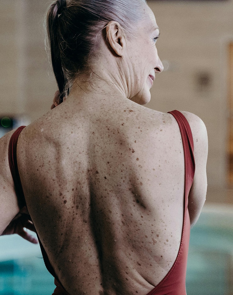 Back view of an elderly woman in maroon swimwear