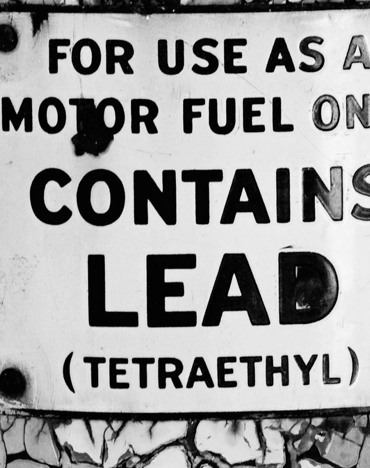 black and white danger sign warning of lead in motor fuel