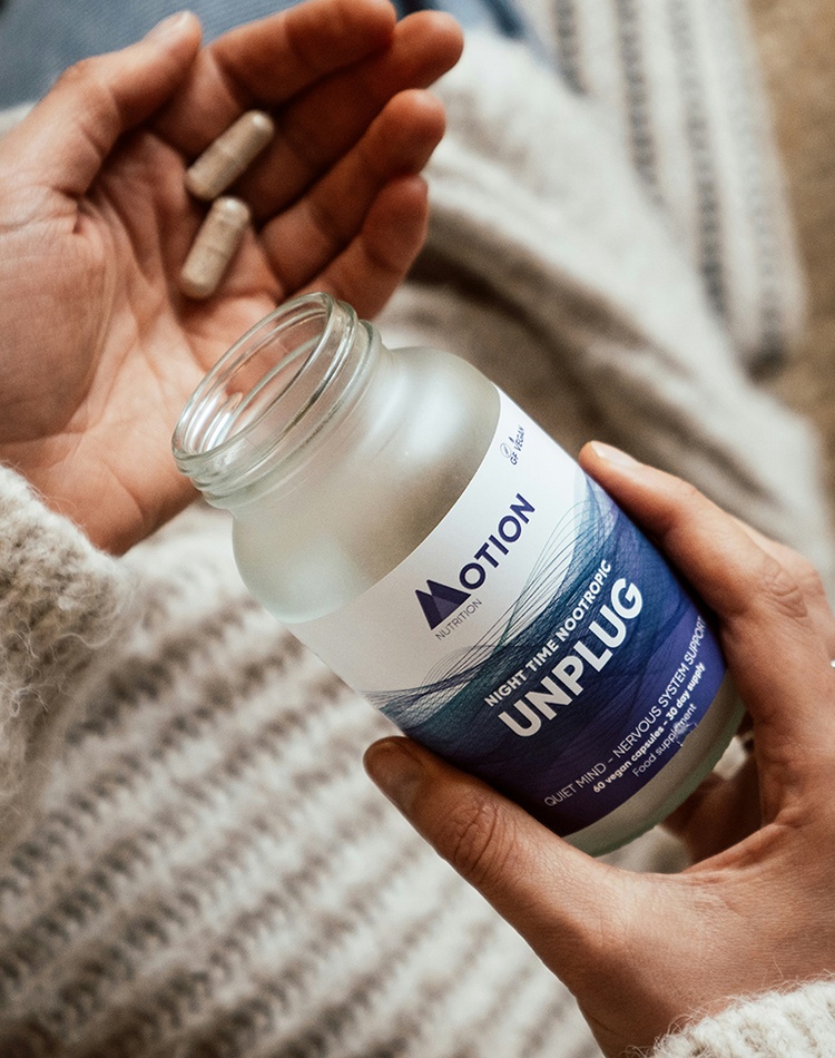 A woman's hands holding a bottle containing health supplements