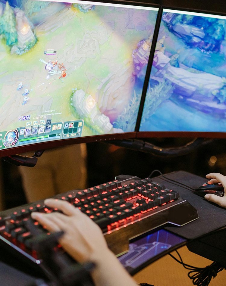 Woman in front of a computer screen playing esports League of Legends