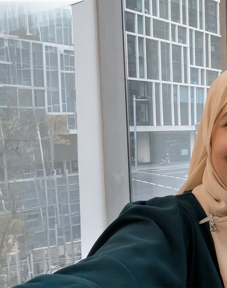 Woman standing in front of a glass window smiling