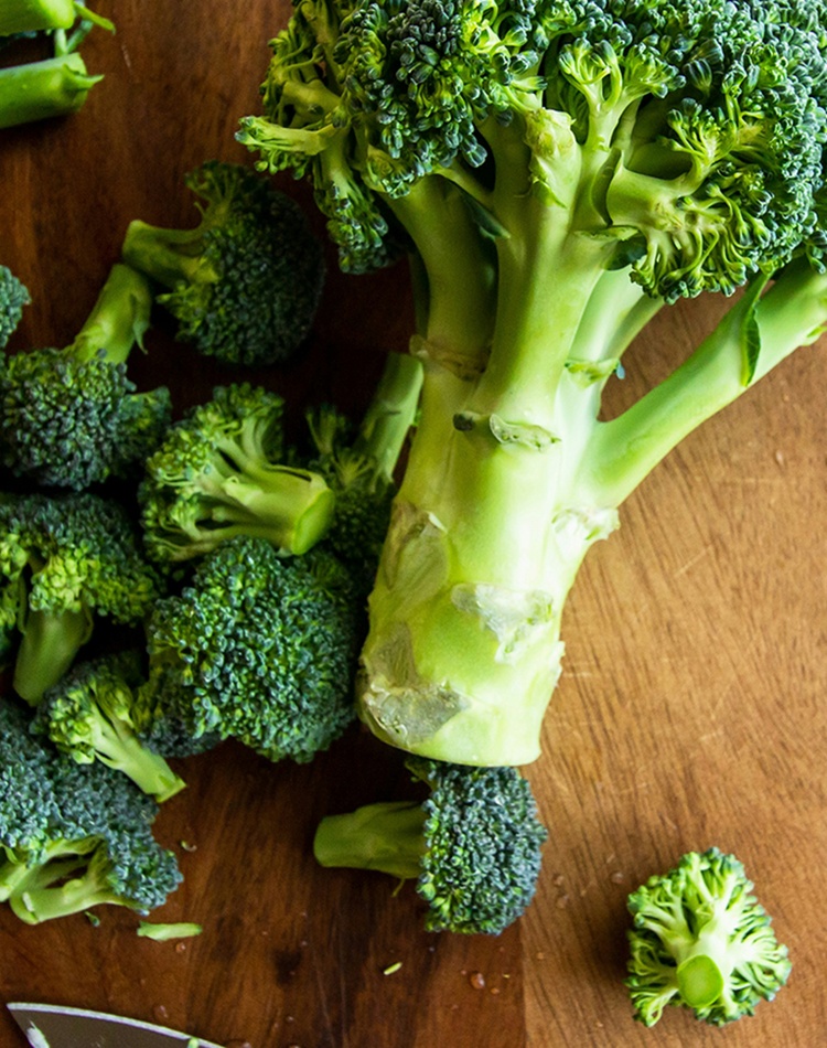 Broccoli on chopping board with a knife