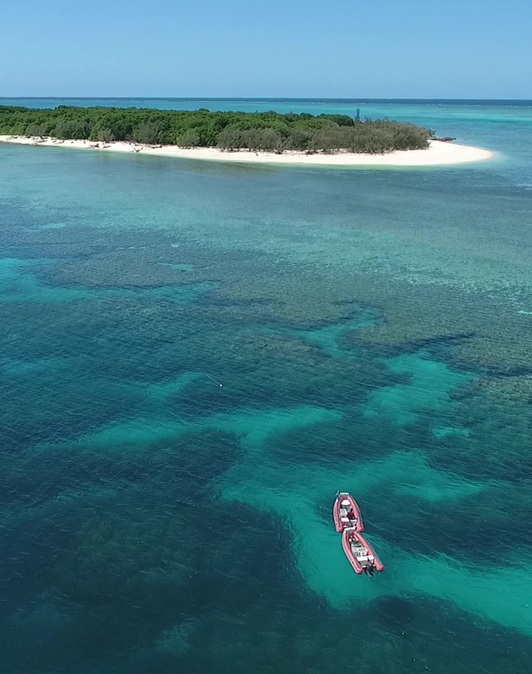Two boats over the reef next to an island