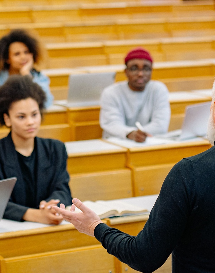 A lecturer standing in front of students in a university lecture room