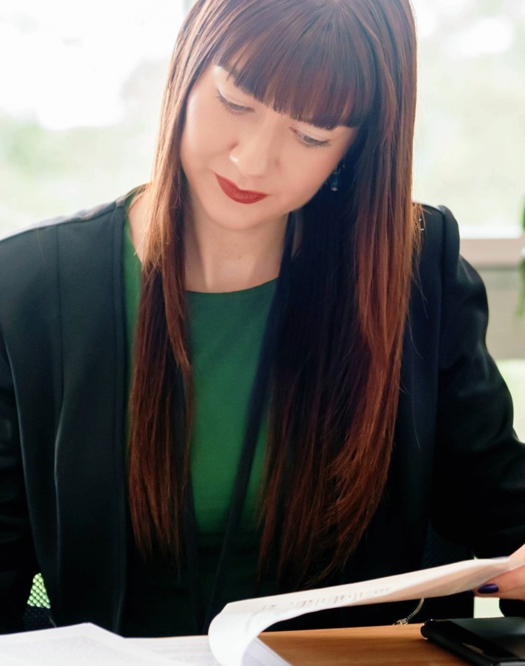 Professional woman sitting at a desk with paperwork