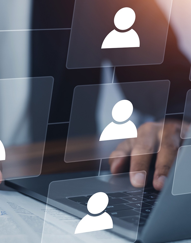 hands above a laptop keyboard pointing to an illustrative overlay of a staff organisational chart