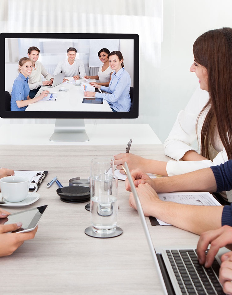 office workers meeting around a table and online