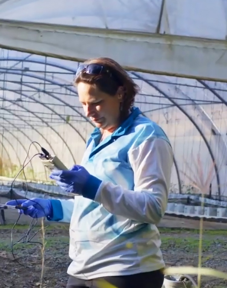 Kirsten Benkendorff sampling in front of greenhouse