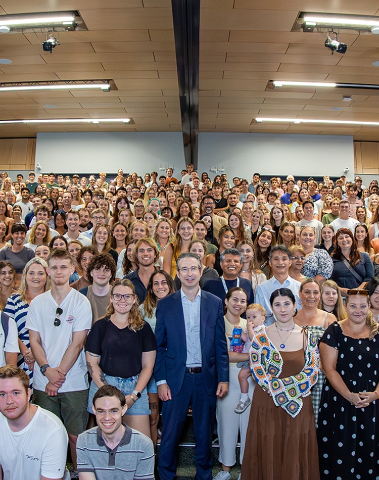 An enormous group of people in an auditorium looking at the camera