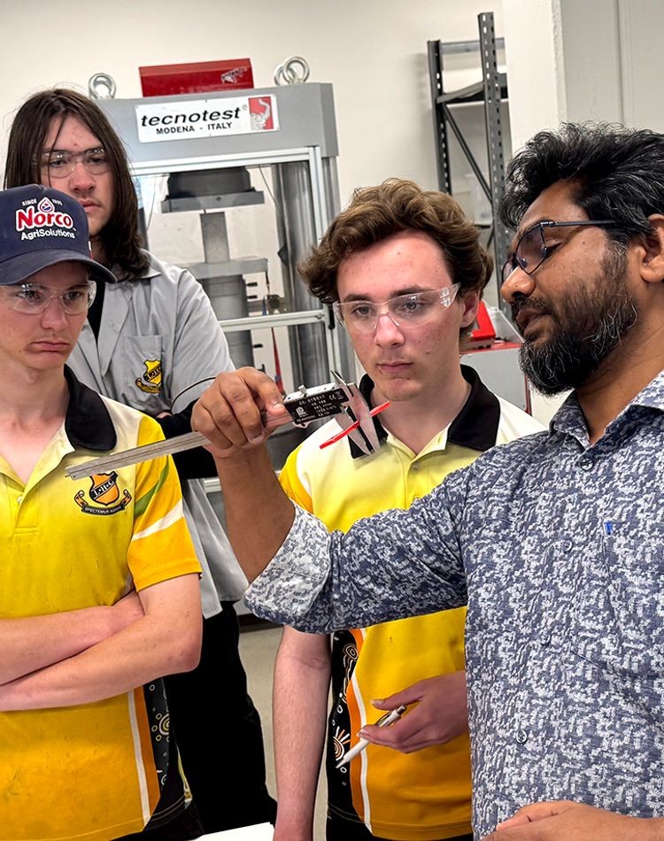 A group of school students and researcher in engineering lab