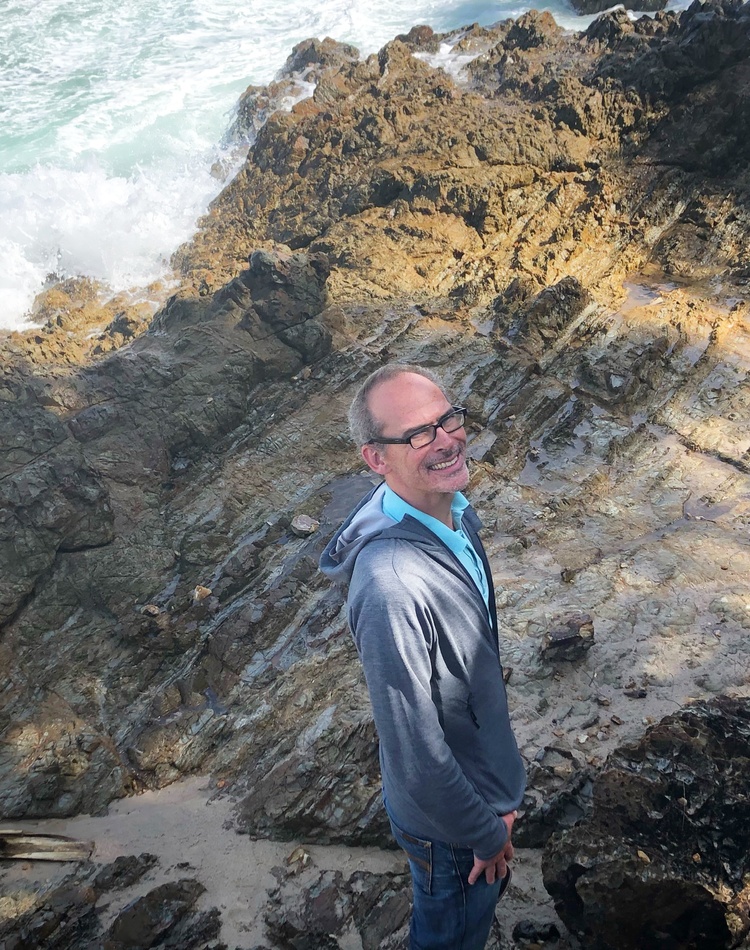 A man standing on a rock shelf