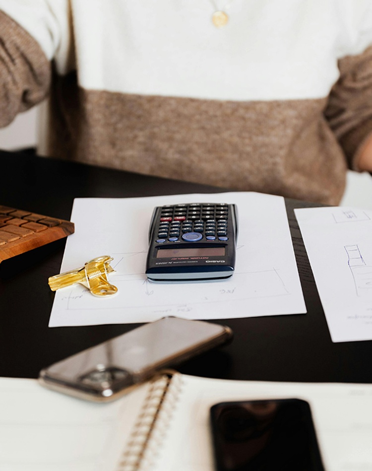 student at desk with calculator