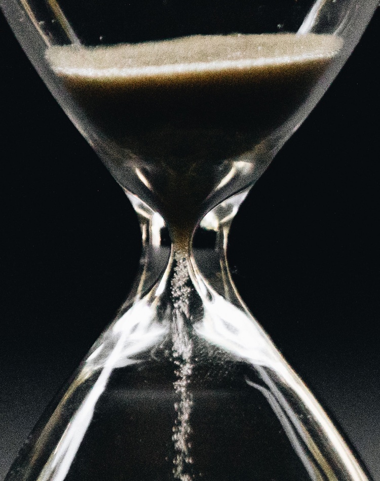 Close-up of sand falling through hourglass