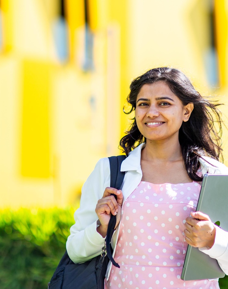 A student holding a laptop on SCU Gold Coast campus