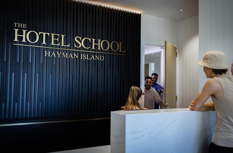 Students mingling at The Hotel School front desk at Hayman Island