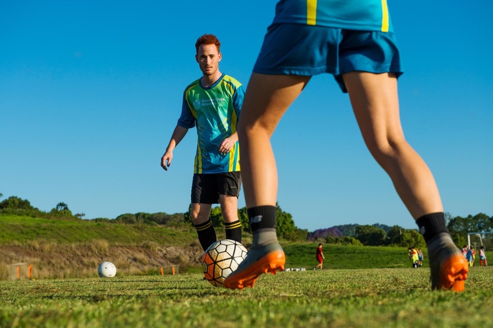 Two students play soccer in SCU uniforms.