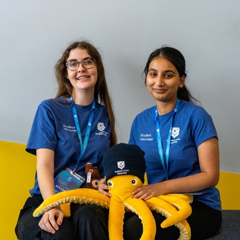 Two Vollies sit together and smile at the camera.