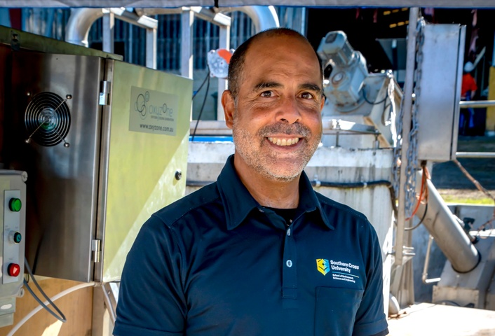 Professor Dirk Erler standing in front of machinery