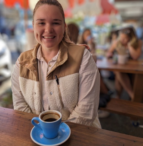 A woman sitting in a cafe with a cup of coffee