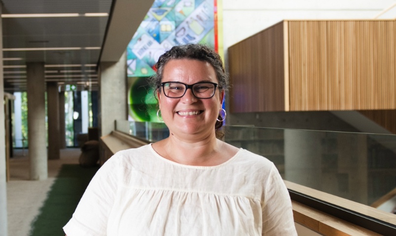 Woman standing in a library smiling