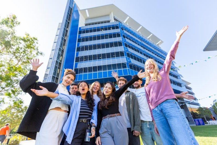 Students smiling in front of building
