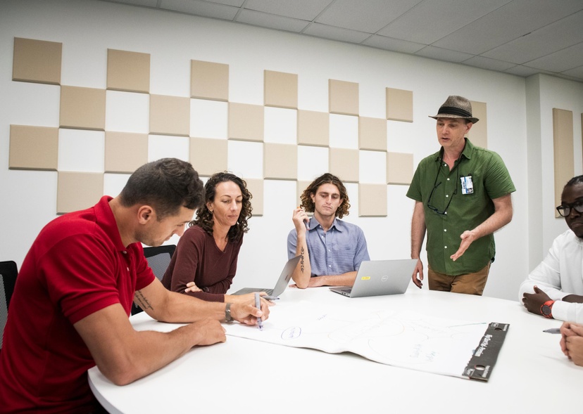 A group of students brainstorm around a table.