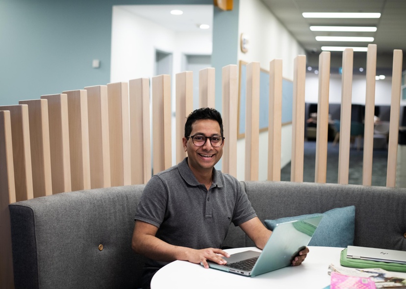 Shreyas Kale with laptop in the Gold Coast campus library