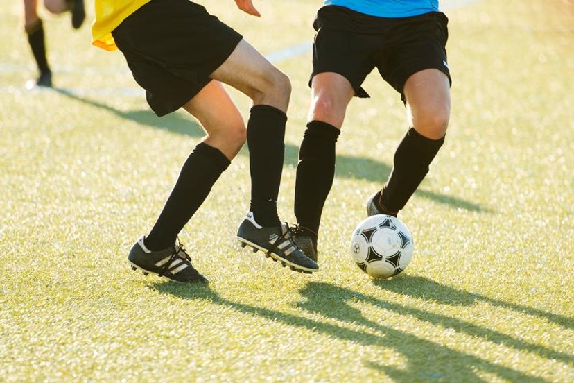 Two students kicking a ball