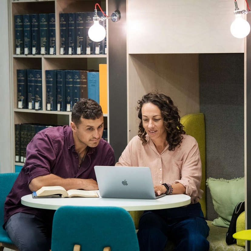 Two students studying in the Gold Coast campus library with a laptop