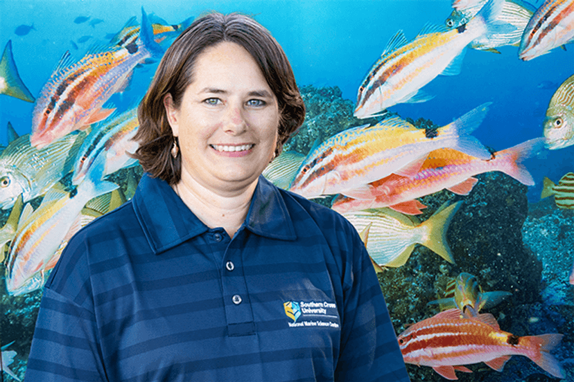 Professor Kirsten Benkendorff smiling in front of fish tank