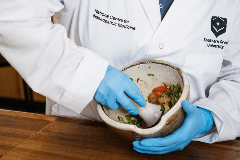 Person crushing food in mortar with pestel
