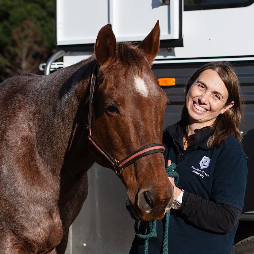 Associate Professor Barbara Padalino smiling while handling horse