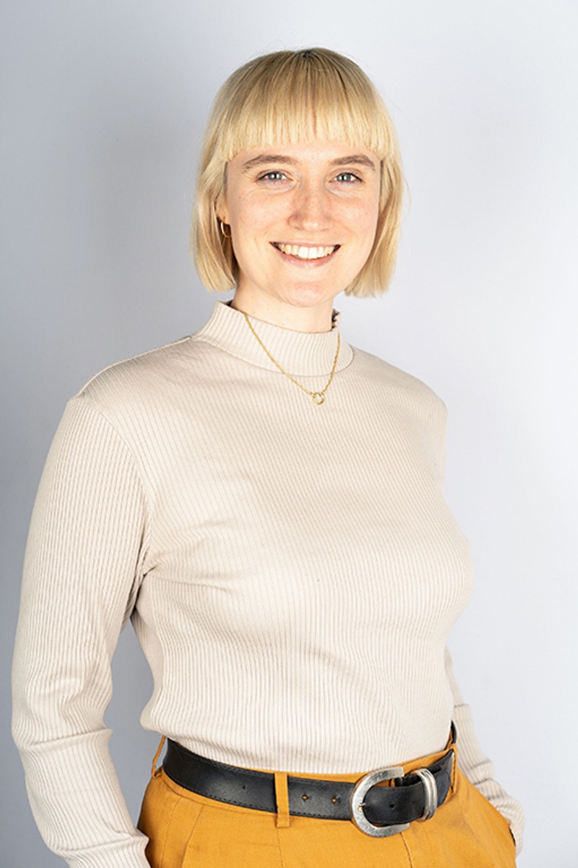 A woman with blonde hair wearing a white jumper