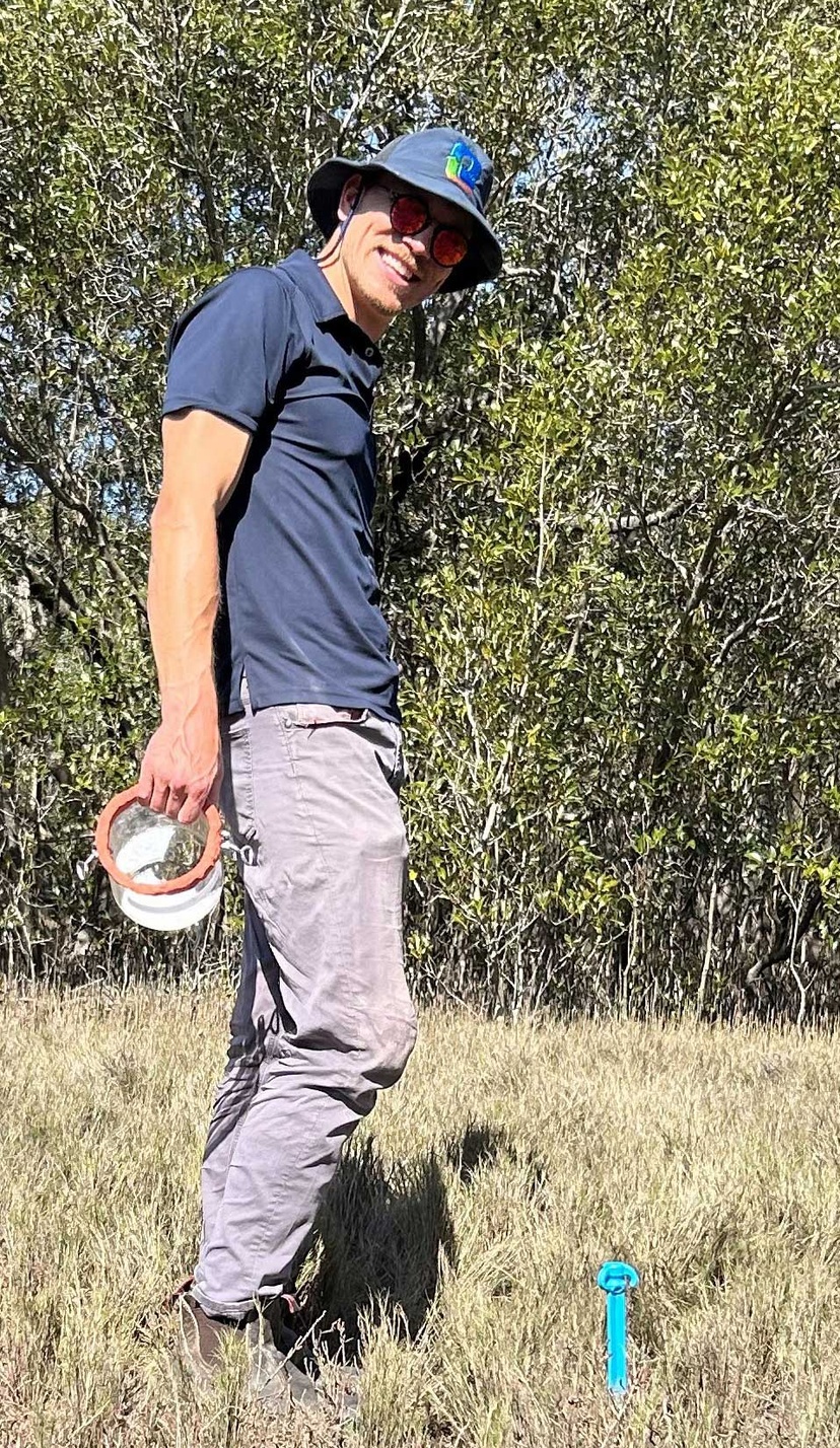 Man in hat with bush behind him