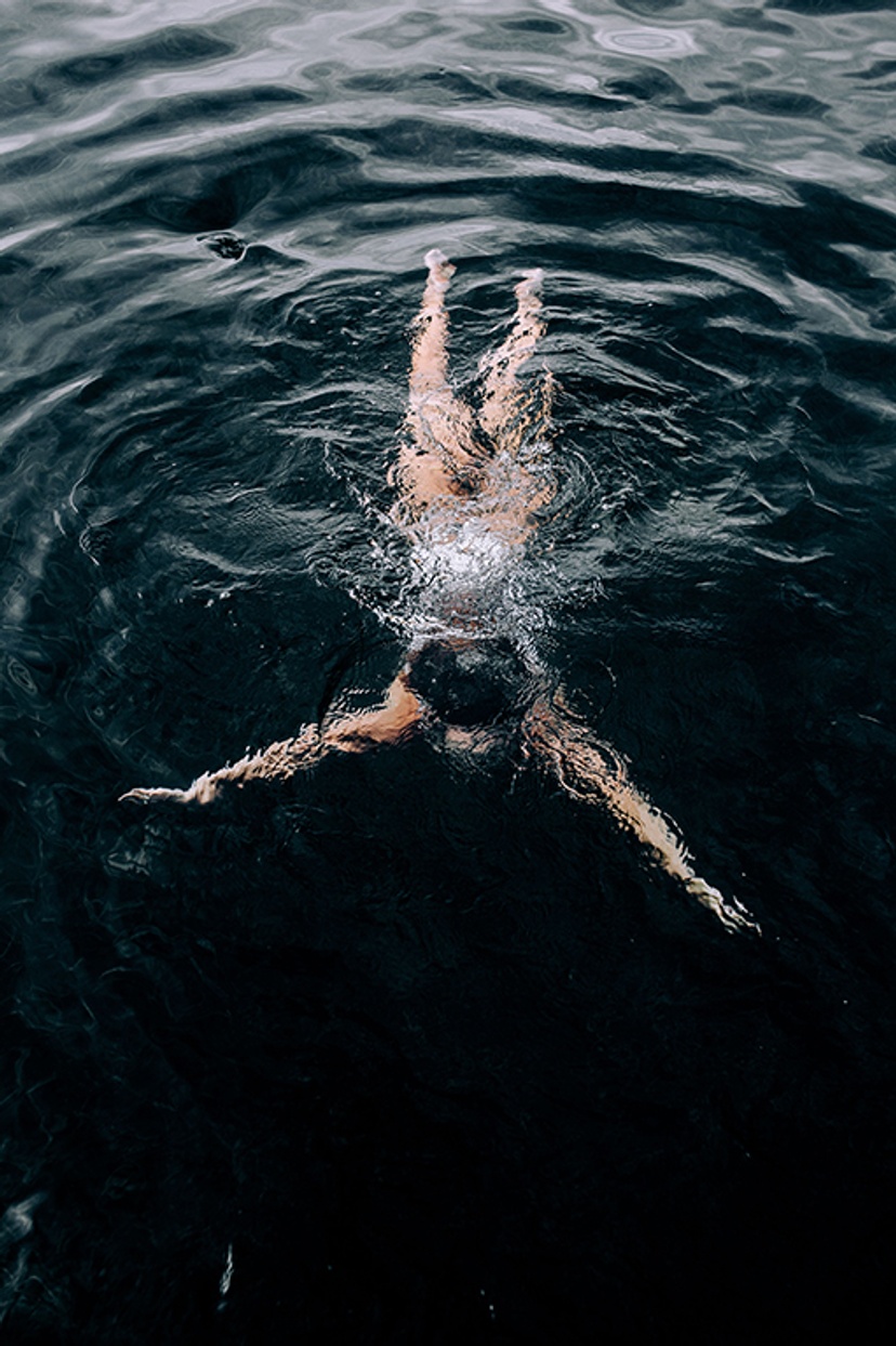 A woman wearing white swimmers in the ocean