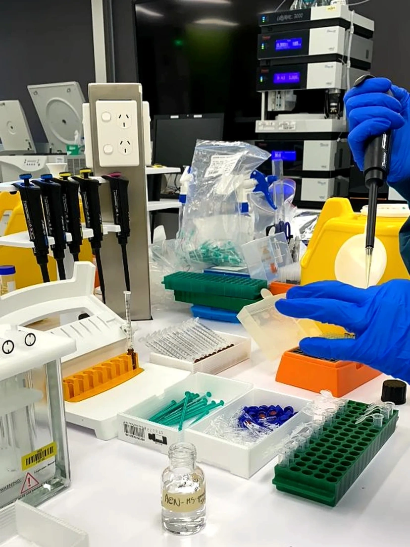 Lab setting of gloved hands using pipette
