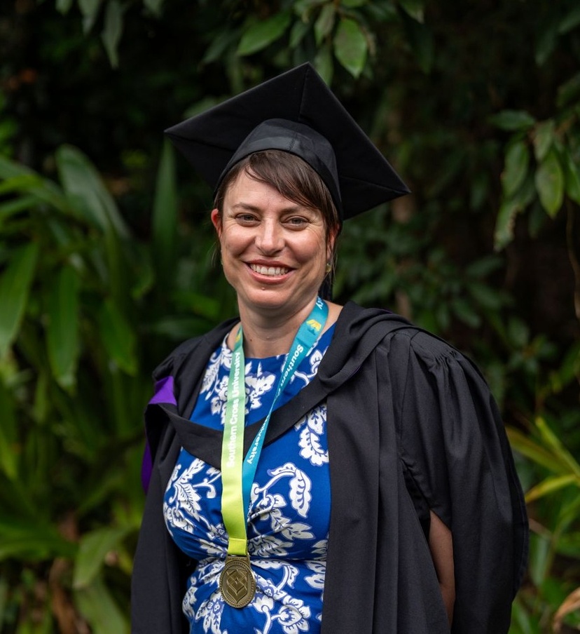 Female in graduation robe smiling at camera