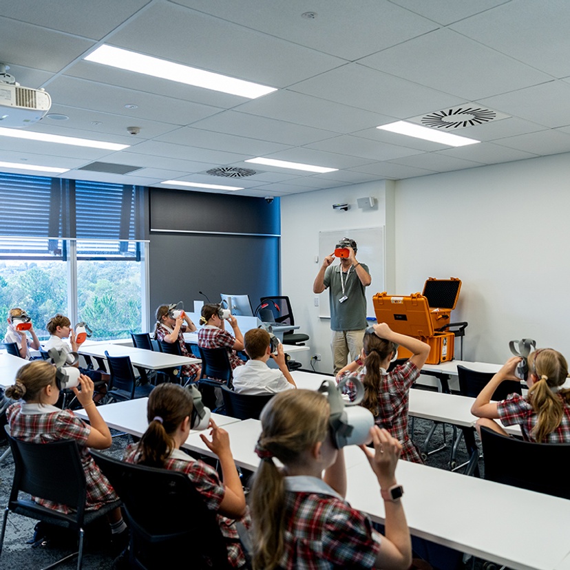 Students experience VR headsets, guided by Associate Professor Christos Markopoulos