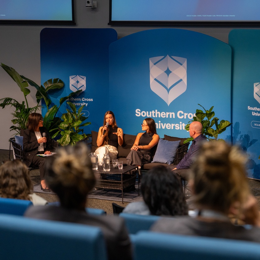 a panel of people sitting in front of SCU logo talking to people in audience