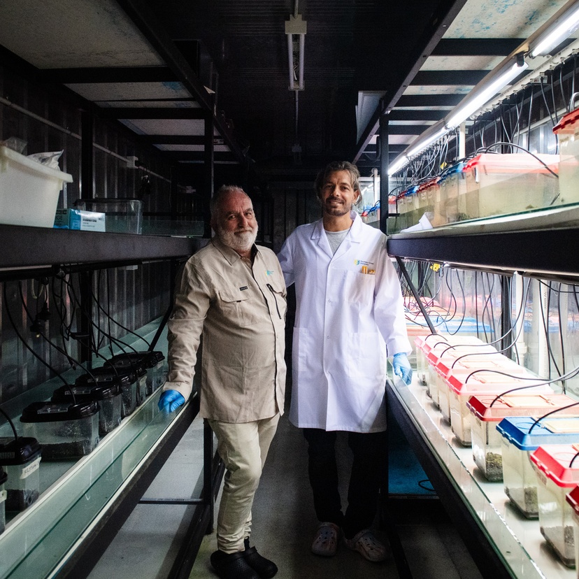 two people standing smiling at camera in lab environment