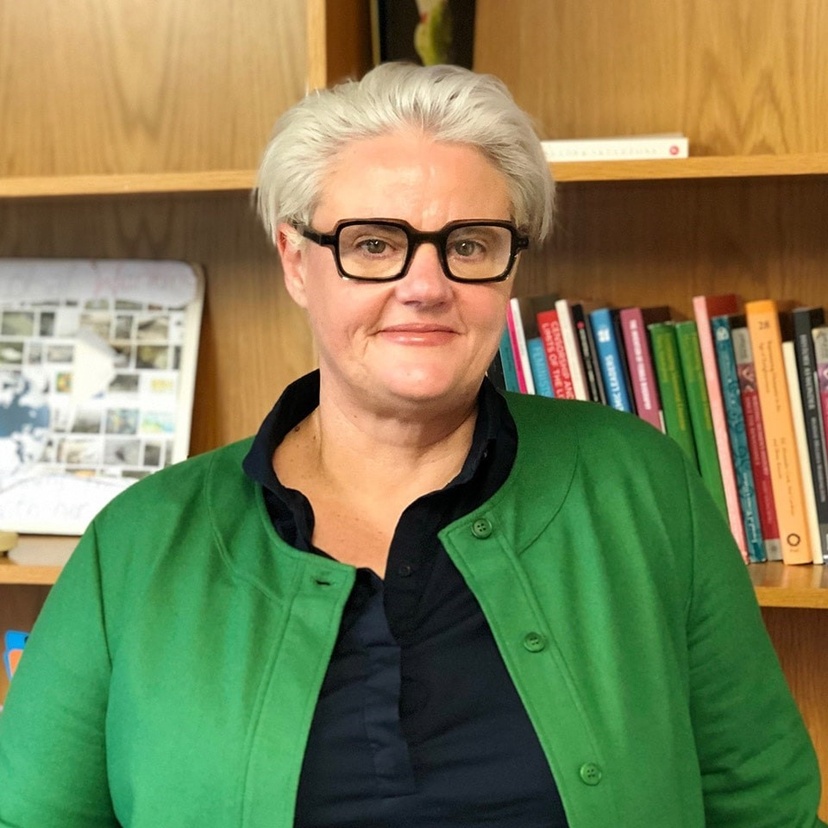 Person looking at camera, wearing black glasses and green jacket