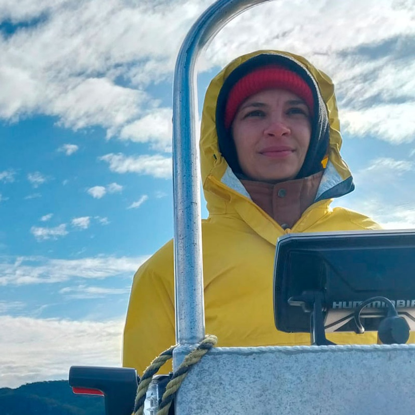 Mona Andskog piloting a boat wearing a raincoat