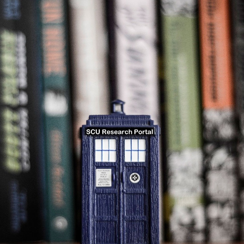 Close up view of tardis-like phone box in front of a bookshelf