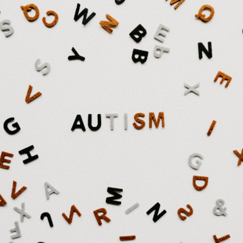 Alphabet letters scattered around the word autism