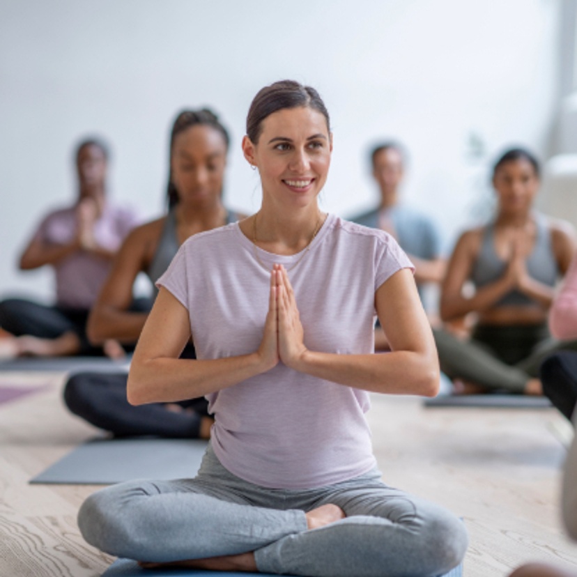Woman doing yoga in a class with prayer hands