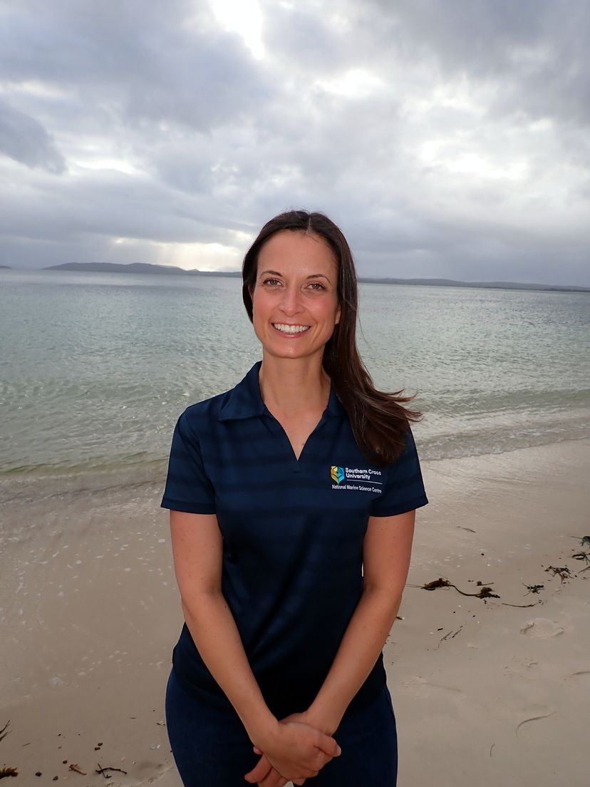 female student standing on sandy shore
