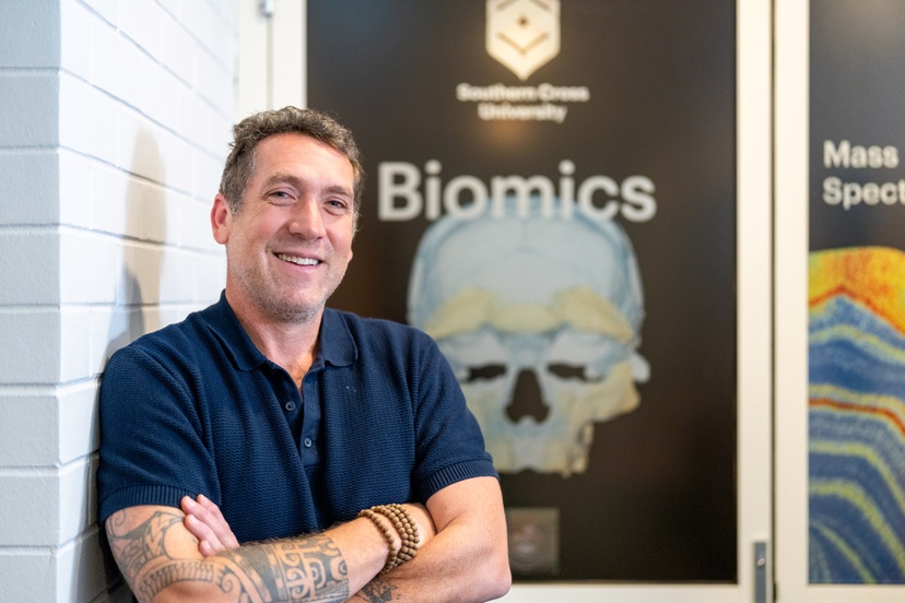 A staff member with arms crossed outside lab