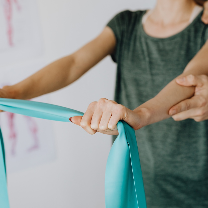 A personal using a stretch band under supervision of clinician